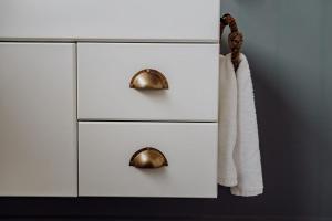 a white dresser with two handles and a towel at Sailor's Catch in Hokitika