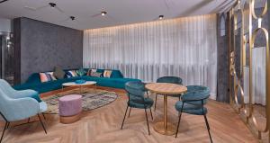 a living room with a blue couch and chairs at Occidental Alicante in Alicante