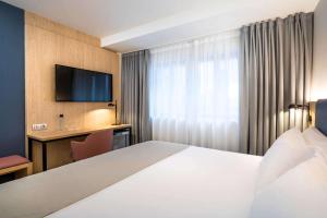 a hotel room with a bed and a television at Occidental Alicante in Alicante