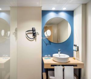 a bathroom with a sink and a mirror at Occidental Alicante in Alicante