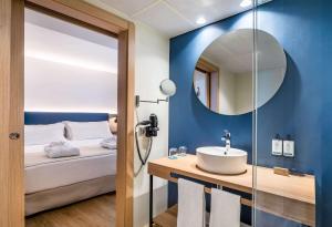 a bathroom with a sink and a mirror at Occidental Alicante in Alicante