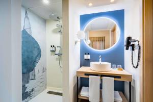 a bathroom with a sink and a mirror at Occidental Alicante in Alicante