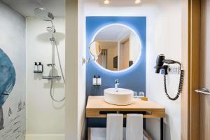 a bathroom with a sink and a mirror at Occidental Alicante in Alicante
