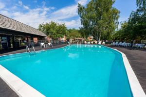 a large blue swimming pool next to a building at Fireside Inn & Suites Portland in Portland +18 photos