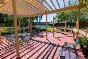 a patio with a table and chairs under a pergola at Fireside Inn & Suites Portland in Portland