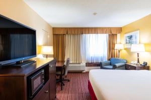 a hotel room with a bed and a flat screen tv at Fireside Inn & Suites Portland in Portland