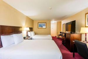 a hotel room with two beds and a flat screen tv at Fireside Inn & Suites Portland in Portland
