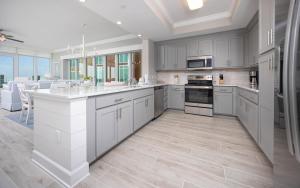 a large kitchen with white cabinets and a kitchen island at Phoenix Gulf Towers 405 condo in Gulf Shores