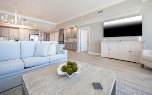 a living room with a blue couch and a large tv at Phoenix Gulf Towers 405 condo in Gulf Shores