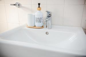 a bathroom sink with a bottle of hand soap on it at Dortmunder Stadtoase in Dortmund +41 photos