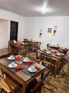 a dining room with wooden tables and wooden chairs at Pousada Areias de Amaro in Santo Amaro