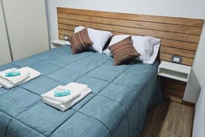 a large blue bed with towels on top of it at Ush in Ushuaia