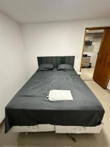 a large bed in a room with a mirror at Apto 2 quartos perto da praia in Rio de Janeiro +3 photos