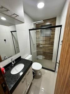 a bathroom with a toilet and a sink and a shower at Apto 2 quartos perto da praia in Rio de Janeiro