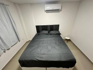 a bedroom with a large bed in a white room at Apto 2 quartos perto da praia in Rio de Janeiro