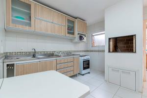 a kitchen with a sink and a stove at Amplo e Central Apartamento 3 Quartos in Gramado