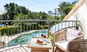 un patio con tavolo e sedie accanto alla piscina di Highwater Haven - Ocean View Apartment. 300m to Beach. Pet Friendly ad Alexandra Headland