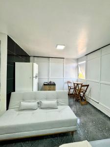 a living room with a couch and a refrigerator at Apartamento Asa Norte com Varanda in Brasilia