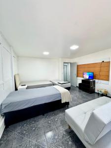 a bedroom with two beds and a flat screen tv at Apartamento Asa Norte com Varanda in Brasilia