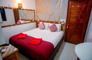 a bedroom with a bed with red pillows on it at Pousada do Bispo in Cabo Frio +121 photos