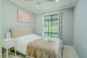 Un pat sau paturi într-o cameră la Exclusive Manor Retreat Farm Stay Pool 5BD