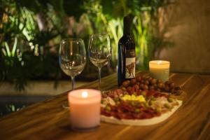 a table with a plate of food and two wine glasses at Casa Clementina Luxe Rustic Haven 5 star Location in Mérida
