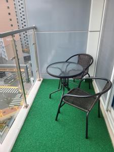 a table and two chairs on a balcony with green carpet at Central City AIR9 in Incheon