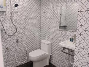 a white bathroom with a toilet and a sink at Perhentian Bay Chalet in Perhentian Islands