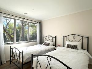 2 camas en un dormitorio con ventana en Spacious Family Home Near Melbourne CBD, en Melbourne
