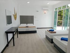 a bedroom with two beds and a desk in it at Perhentian Bay Chalet in Perhentian Island +74 photos