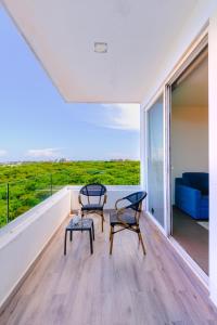 two chairs and a table on the balcony of a house at Azulea Isla Mujeres Hotel in Isla Mujeres +74 photos