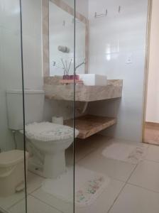 a bathroom with a toilet and a glass shower at Casa aconchegante - Morada do Sol in Piranhas +17 photos