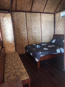ein kleines Zimmer mit einem Bett und einer Bank darin in der Unterkunft Villa panrangluhu in Bira + 43 Fotos