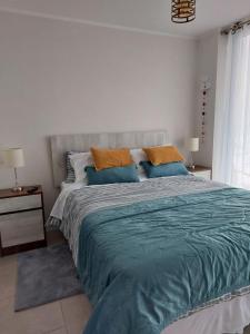 a bedroom with a large bed with blue pillows at Sunrise in La Serena +27 photos
