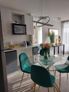 a kitchen with a glass table and green chairs at Sunrise in La Serena