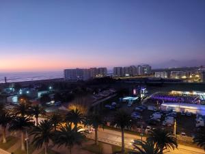 a city at night with palm trees and the ocean at Sunrise in La Serena