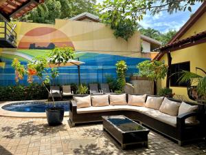a patio with a white couch and a pool at Tamarindo Backpackers in Tamarindo