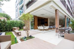 a patio with chairs and tables in a building at Unique (Ex-Estanconfor) veja o mar do apto 703 in Santos