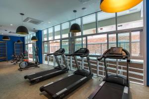 a gym with several treadmills in a room with windows at Unique (Ex-Estanconfor) veja o mar do apto 703 in Santos