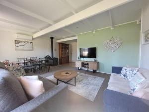 a living room with a couch and a table at Waterfront Retreat by Book Jervis Bay Getaway Kayaks, Bikes, Fast Wi-Fi and more in Sanctuary Point