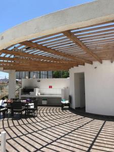 un patio con tavoli e sedie sotto un tetto in legno di Departamento con 3 habitaciones para 4 personas playa la Herradura a Coquimbo