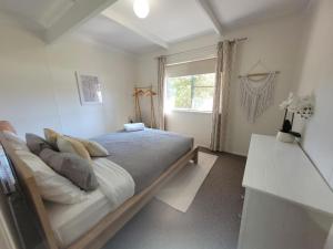 a bedroom with a large bed and a window at Waterfront Retreat by Book Jervis Bay Getaway Kayaks, Bikes, Fast Wi-Fi and more in Sanctuary Point