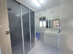 a bathroom with a shower and a toilet and a sink at Waterfront Retreat by Book Jervis Bay Getaway Kayaks, Bikes, Fast Wi-Fi and more in Sanctuary Point +19 photos