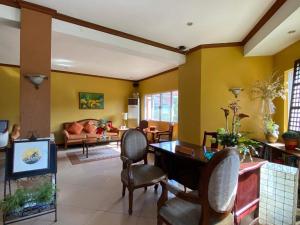 a living room with yellow walls and a table and chairs at Casa Cecilia Heritage Hotel in Taal