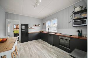a kitchen with a table and a black refrigerator at Summer Breeze Forster in Forster