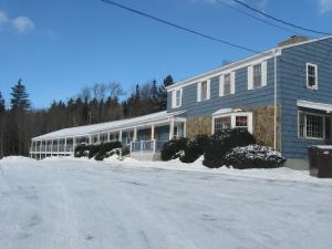 a blue house with snow in front of it at Big Bears Lodge in West Dover