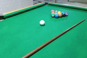 a green pool table with a group of balls at Casa do Barney Enseada Guaruja in Ilha de Santo Amaro