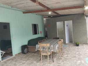 a room with a table and chairs and a bed at Casa do Barney Enseada Guaruja in Ilha de Santo Amaro