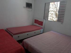 two beds in a small room with a window at Casa do Barney Enseada Guaruja in Ilha de Santo Amaro +14 photos