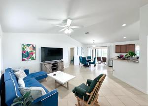 a living room with a blue couch and a tv at Experience Fun Starts Here w Pool & Wifi in Port Charlotte